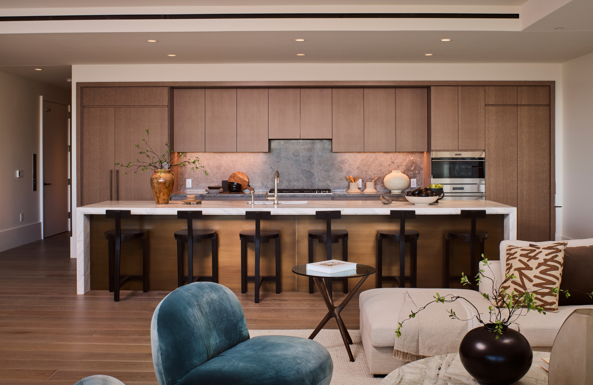 Contemporary open kitchen with wood cabinetry, island seating, and modern decor