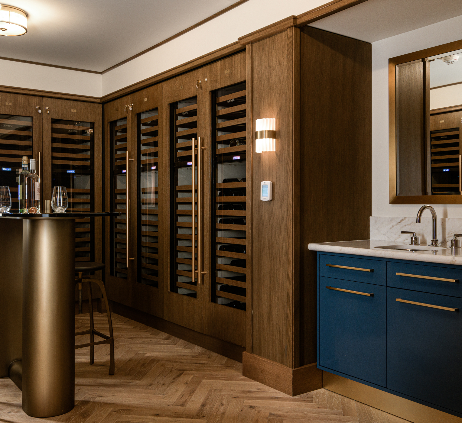 Luxury wine cellar with wood shelving, blue cabinetry, and modern lighting